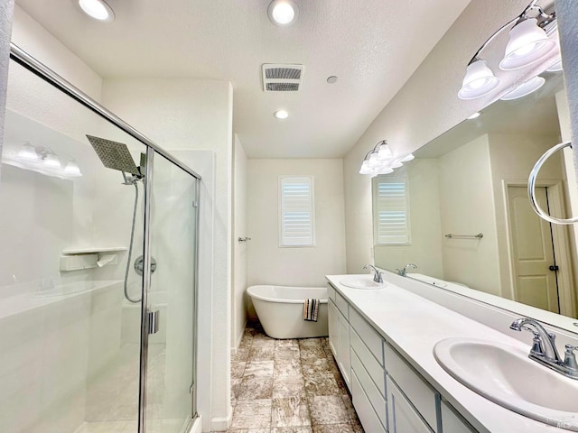 bathroom featuring independent shower and bath, a textured ceiling, and vanity