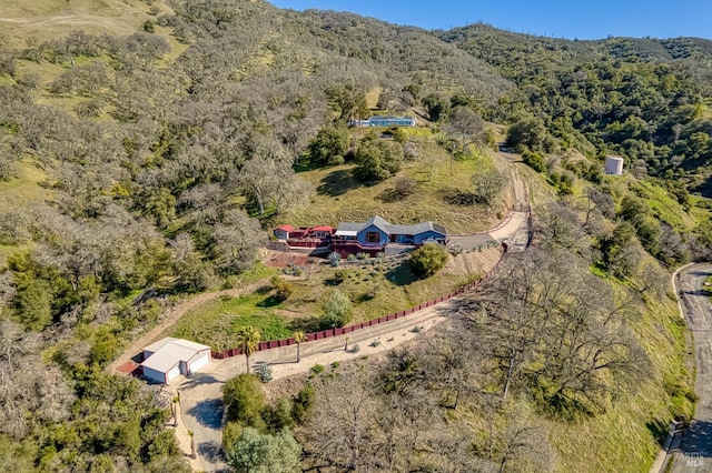 birds eye view of property with a wooded view and a mountain view