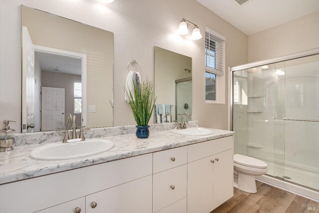 bathroom with toilet, vanity, an enclosed shower, and hardwood / wood-style flooring