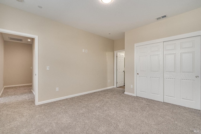 unfurnished bedroom featuring light colored carpet and a closet