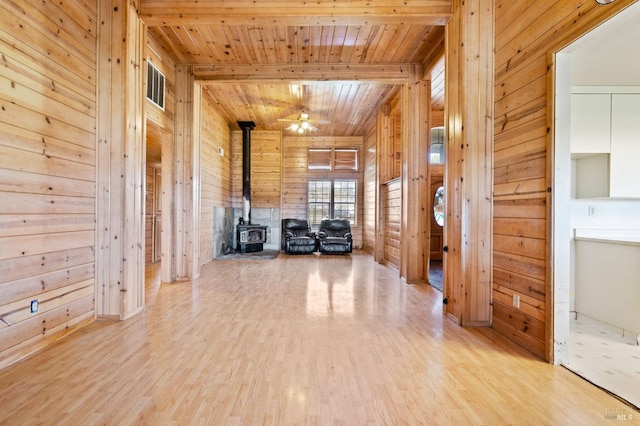 corridor featuring light wood-type flooring, wooden ceiling, and wood walls