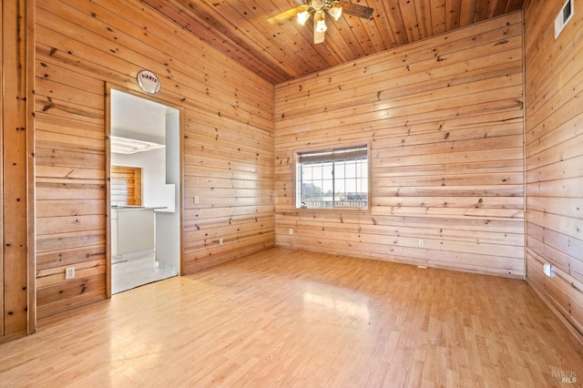 unfurnished room featuring wooden walls, ceiling fan, wood ceiling, and light hardwood / wood-style floors