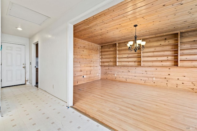 interior space with wooden ceiling, wooden walls, and a notable chandelier