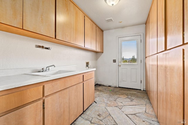 washroom featuring washer hookup, cabinets, and sink