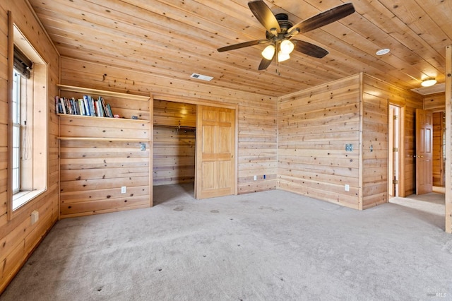 unfurnished bedroom with carpet, a closet, ceiling fan, and wood ceiling