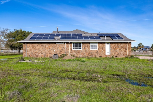 back of house featuring solar panels and cooling unit