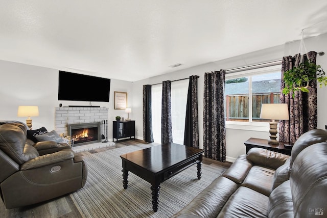 living room with wood-type flooring and a fireplace