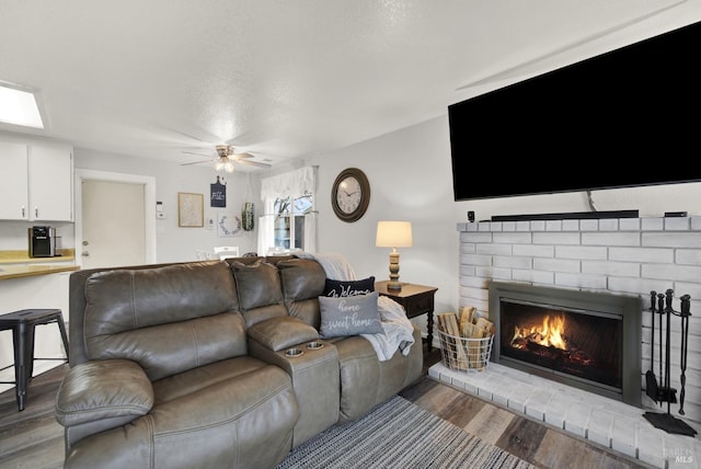 living room with ceiling fan, hardwood / wood-style floors, and a fireplace