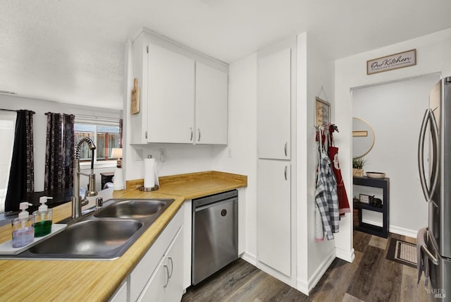 kitchen featuring stainless steel appliances, sink, white cabinets, and dark hardwood / wood-style floors