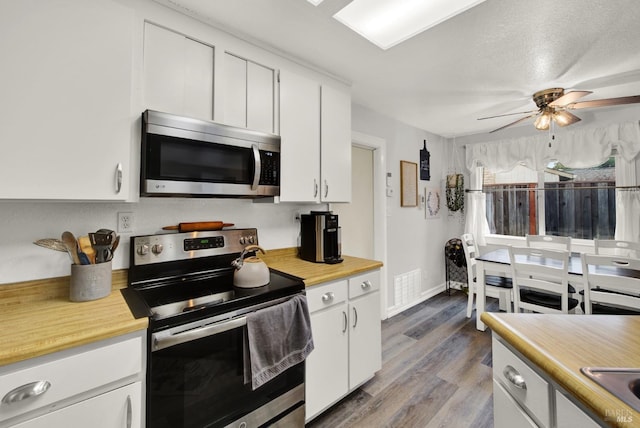 kitchen with ceiling fan, light wood-type flooring, white cabinets, and appliances with stainless steel finishes