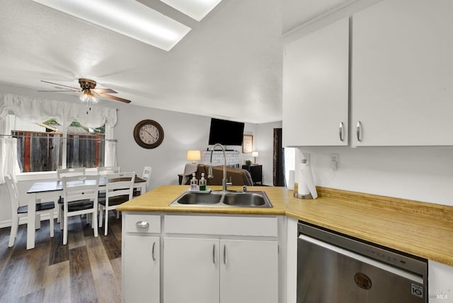 kitchen with sink, dark wood-type flooring, white cabinetry, stainless steel dishwasher, and kitchen peninsula