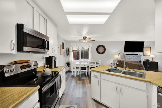 kitchen featuring sink, white cabinets, ceiling fan, stainless steel appliances, and dark wood-type flooring