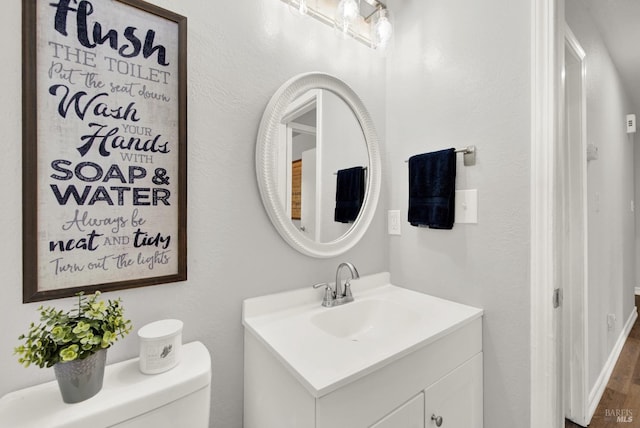 bathroom with vanity, hardwood / wood-style floors, and toilet