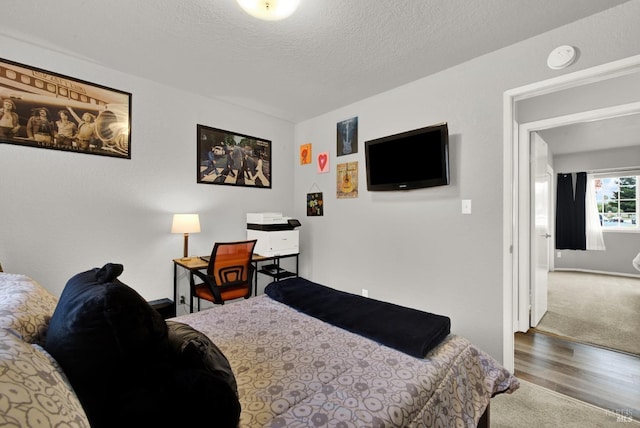 bedroom featuring hardwood / wood-style floors and a textured ceiling