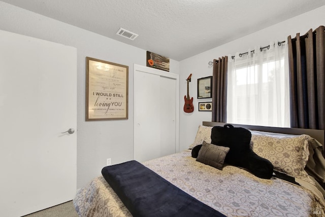 bedroom with a textured ceiling and a closet