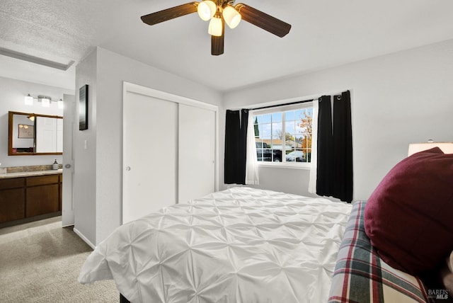 carpeted bedroom with ceiling fan, connected bathroom, and a closet