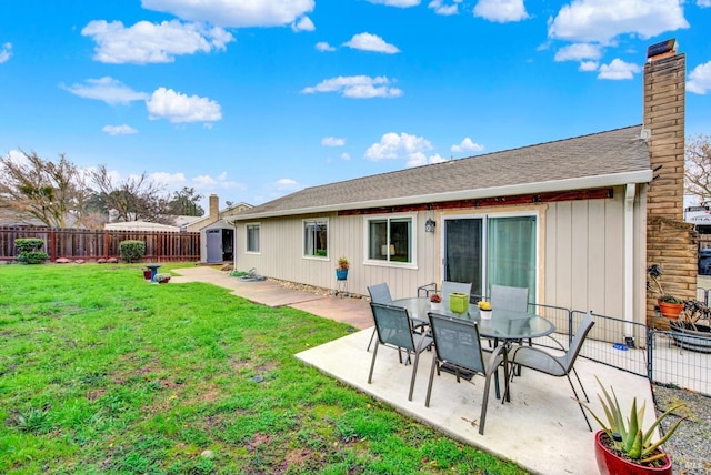 back of property with a patio, a yard, and a shed