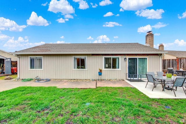 rear view of house with a lawn and a patio