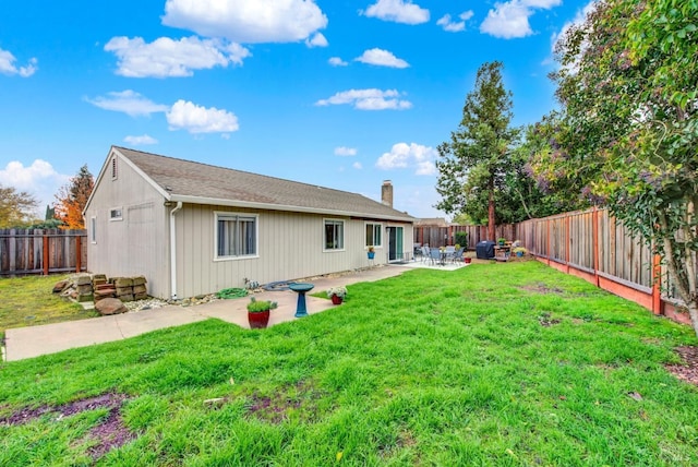 rear view of house featuring a yard and a patio