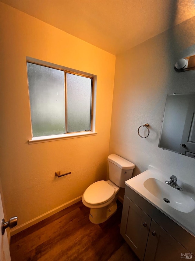 bathroom with toilet, vanity, and hardwood / wood-style flooring