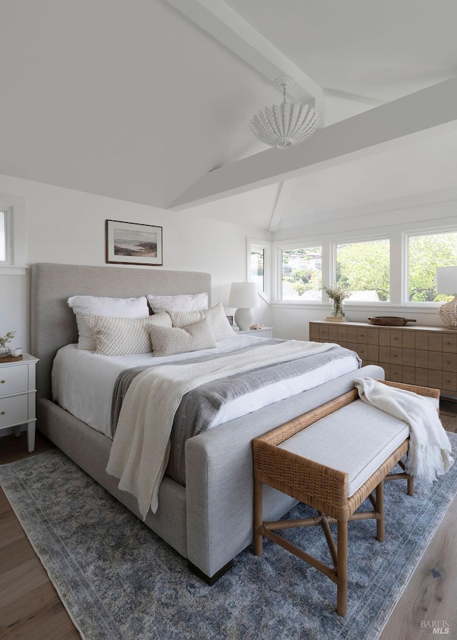 bedroom featuring dark wood-type flooring, lofted ceiling with beams, and a chandelier