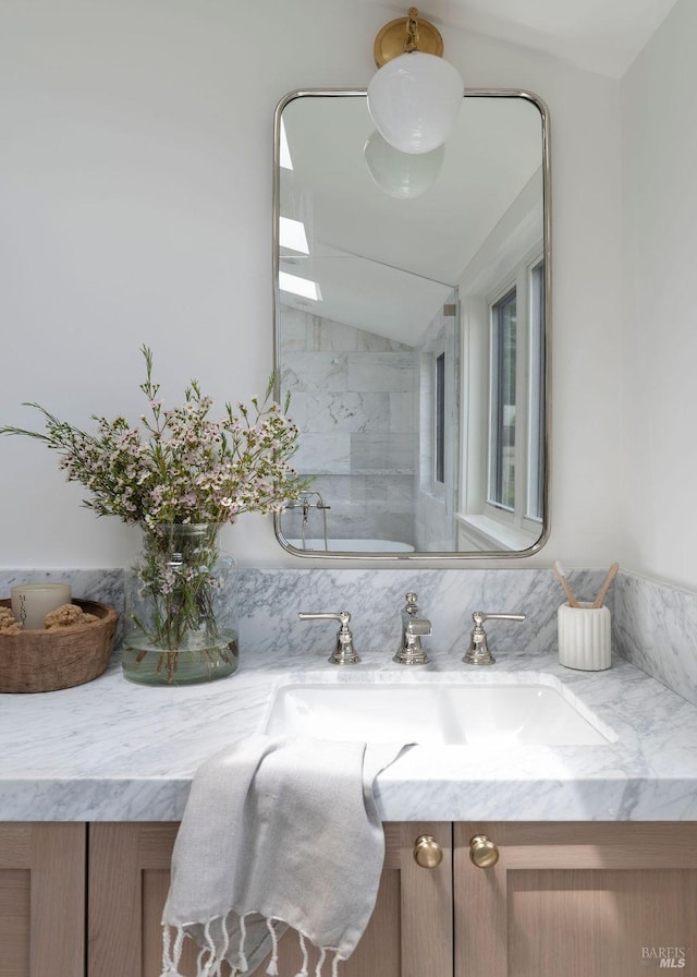 bathroom featuring lofted ceiling and vanity