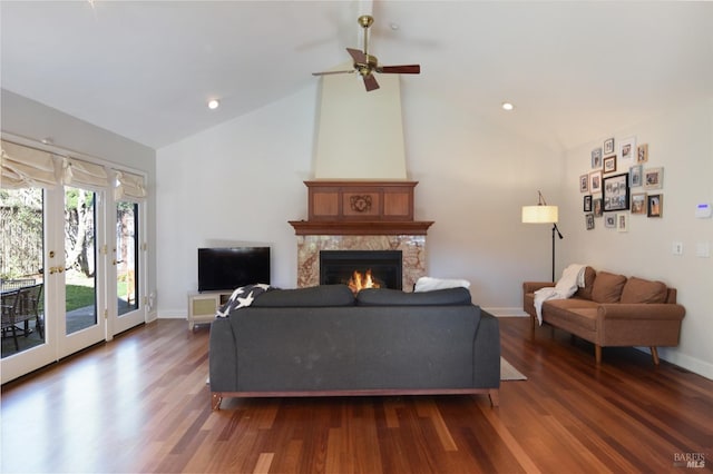 living room with ceiling fan, a fireplace, dark wood-type flooring, and vaulted ceiling