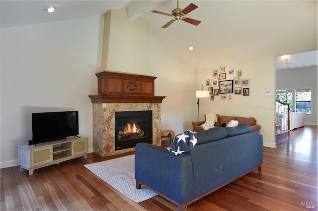 living room with a high end fireplace, beam ceiling, dark hardwood / wood-style floors, and ceiling fan