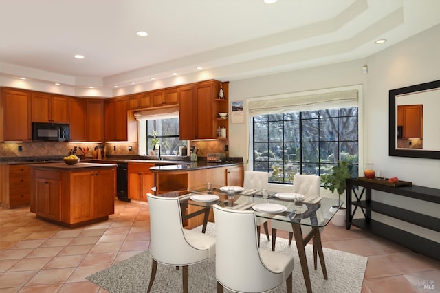 kitchen with light tile patterned flooring, a kitchen island, sink, and tasteful backsplash