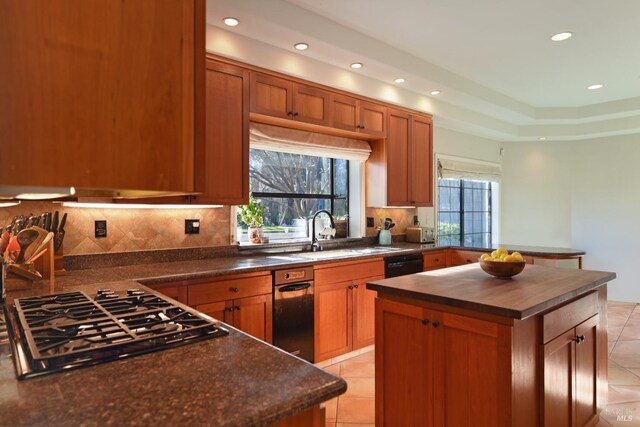 kitchen featuring a center island, light tile patterned floors, sink, and stainless steel gas cooktop