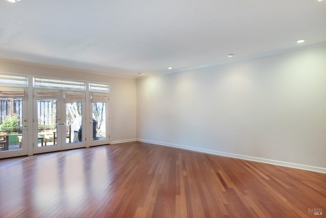 empty room featuring wood-type flooring, crown molding, and french doors