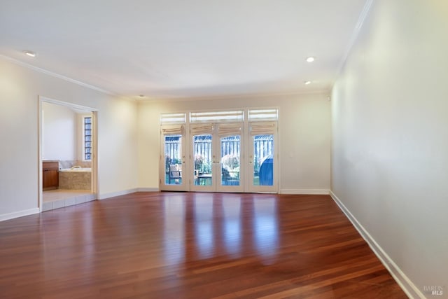 spare room featuring french doors, dark wood-type flooring, and ornamental molding