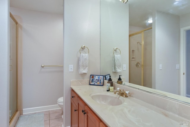 bathroom with tile patterned flooring, vanity, a shower with shower door, and toilet