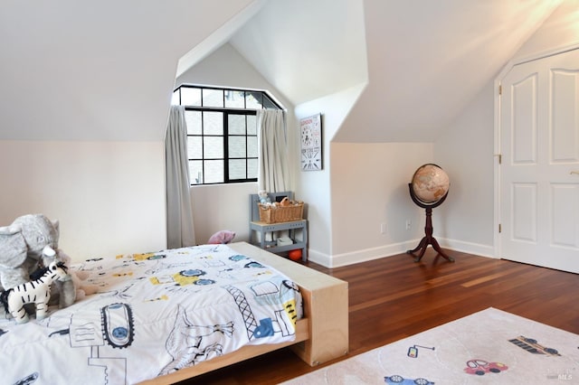 bedroom with dark wood-type flooring and lofted ceiling