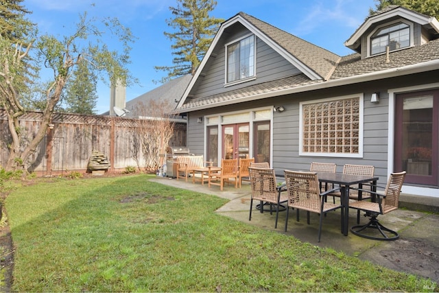 back of house with a yard and a patio