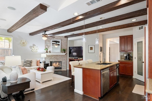 kitchen with pendant lighting, dark wood-type flooring, stainless steel dishwasher, an island with sink, and beam ceiling