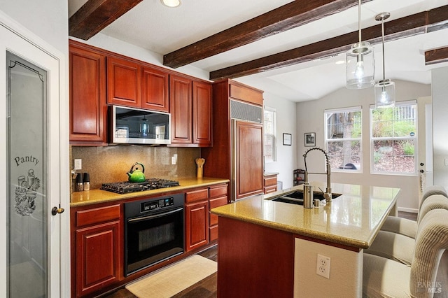 kitchen with a sink, a kitchen island with sink, tasteful backsplash, pendant lighting, and black appliances