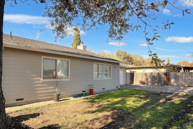 view of side of home with a patio area and a yard