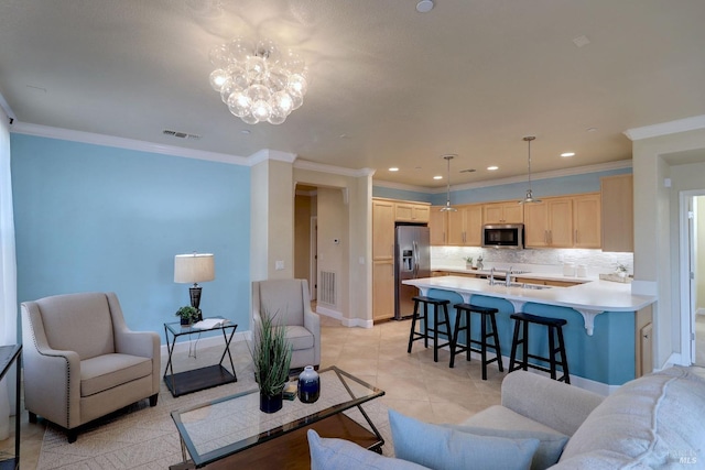 living room with a chandelier, ornamental molding, and sink