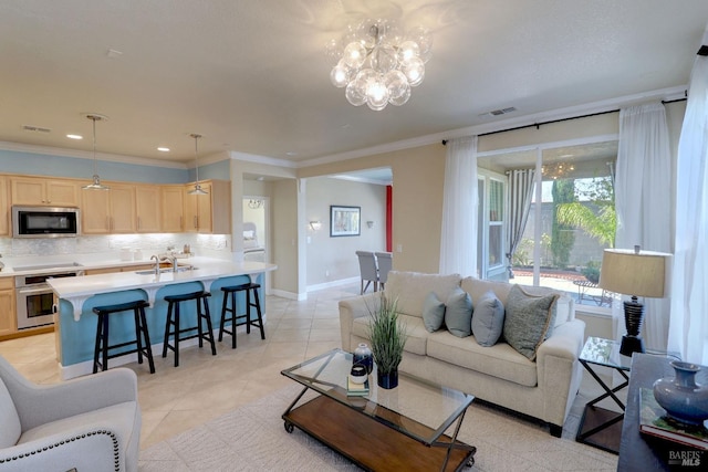 living room featuring crown molding, sink, light tile patterned floors, and a chandelier