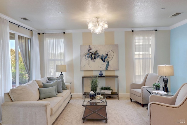 living room featuring ornamental molding, a textured ceiling, and a notable chandelier