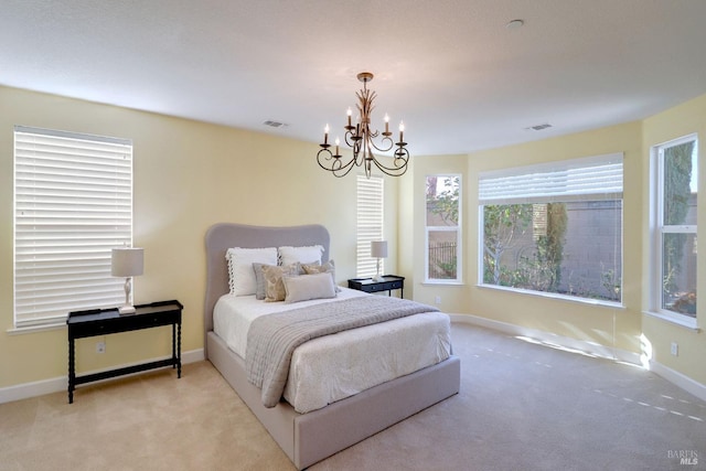 bedroom with a notable chandelier and light colored carpet