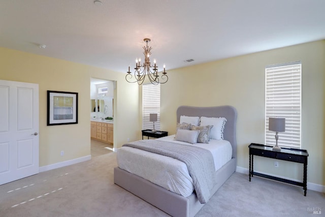 bedroom with an inviting chandelier, light colored carpet, and ensuite bath