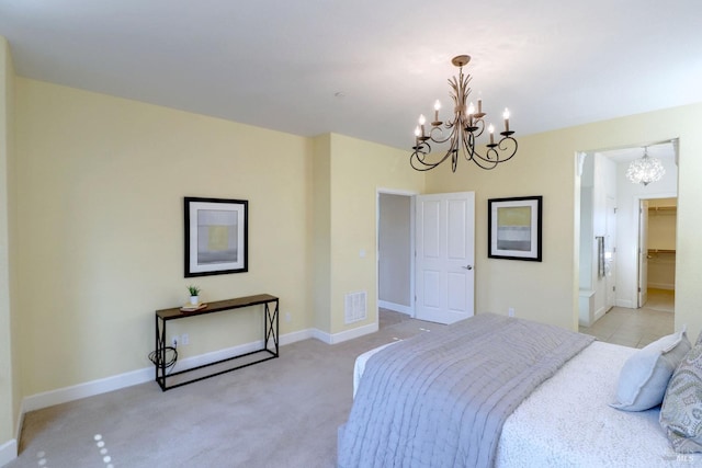 carpeted bedroom with a walk in closet and an inviting chandelier