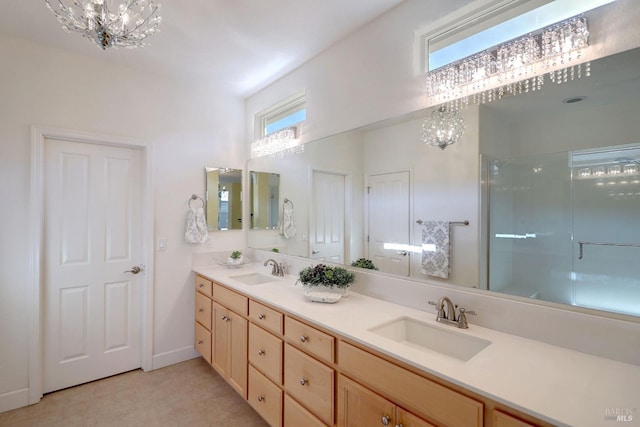 bathroom with a shower with door, vanity, and a notable chandelier