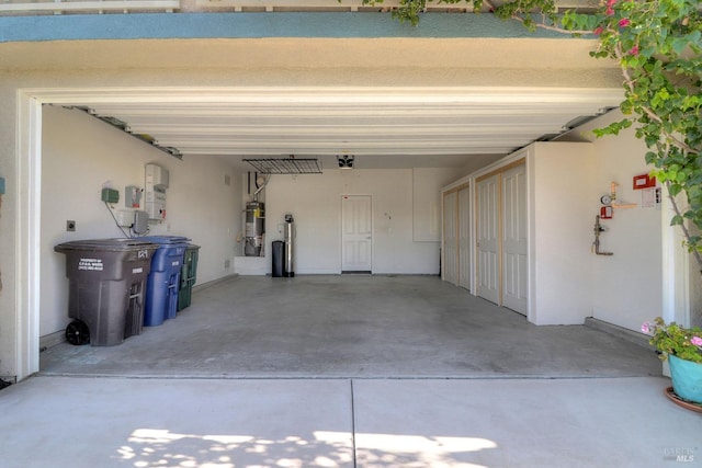 garage featuring water heater, a garage door opener, and a carport