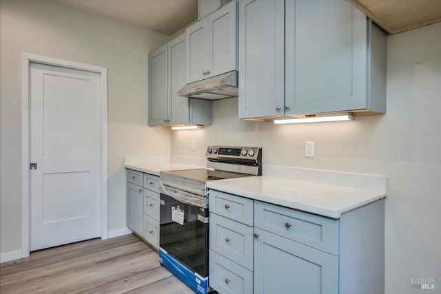 18904 Timber Point Ct, Hidden Valley Lake, CA 95467 - kitchen with light wood finished floors, electric stove, under cabinet range hood, light countertops, and baseboards