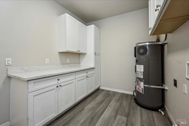 interior space featuring water heater, light stone countertops, white cabinets, and dark hardwood / wood-style flooring