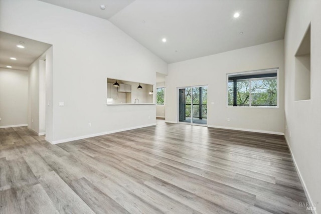 18904 Timber Point Ct, Hidden Valley Lake, CA 95467 - unfurnished living room with baseboards, high vaulted ceiling, wood finished floors, and a wealth of natural light