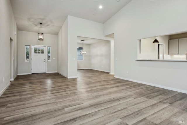 entrance foyer with a towering ceiling and light hardwood / wood-style flooring